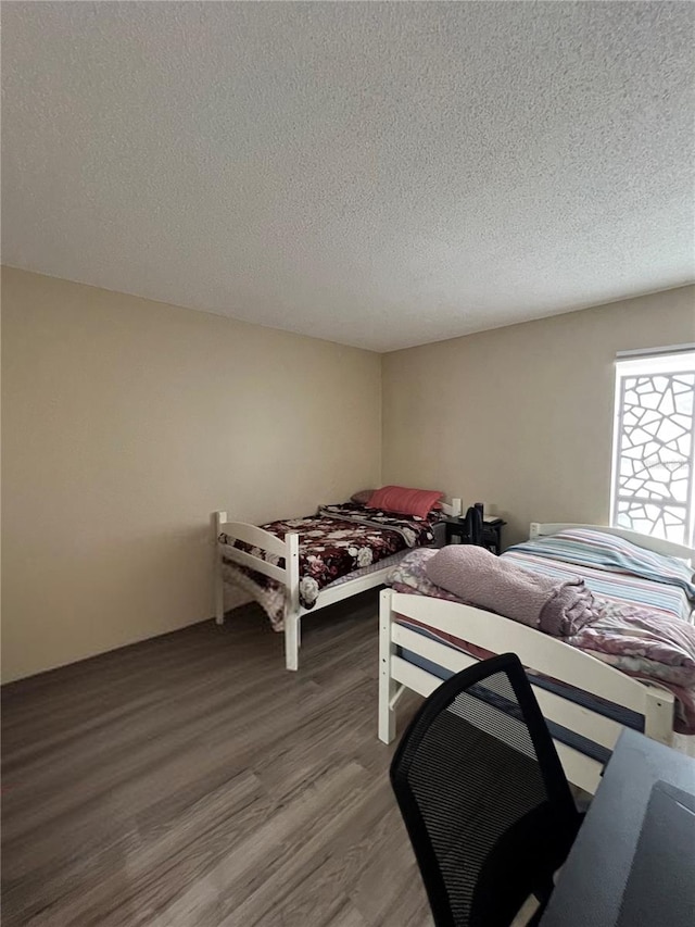 bedroom with hardwood / wood-style flooring and a textured ceiling