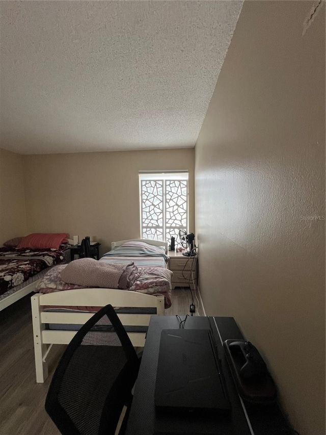 bedroom with hardwood / wood-style flooring and a textured ceiling