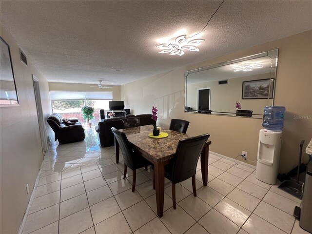 tiled dining space with ceiling fan and a textured ceiling