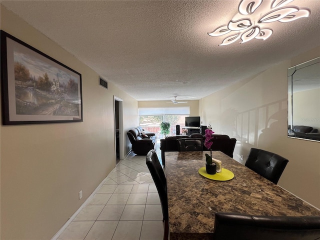 dining room featuring ceiling fan, light tile patterned floors, and a textured ceiling