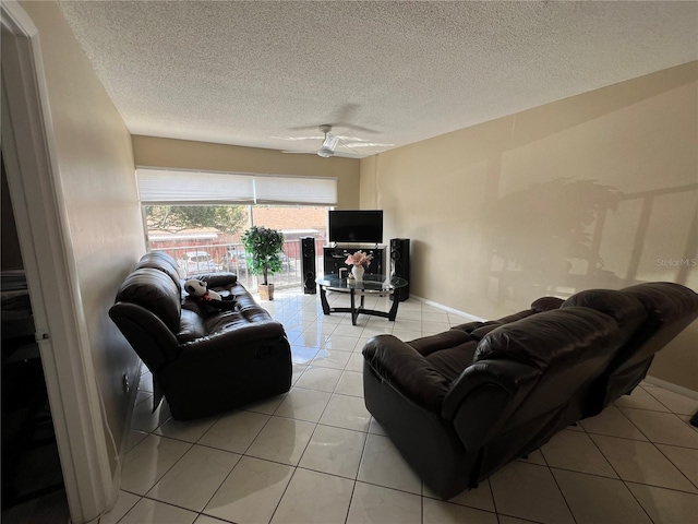 living room with light tile patterned floors, a textured ceiling, and ceiling fan