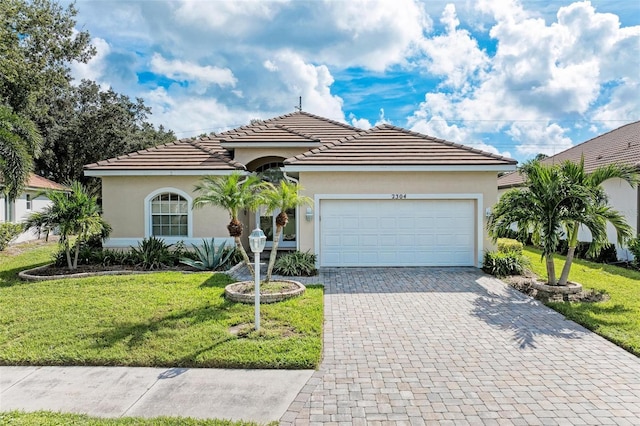 mediterranean / spanish house featuring a front lawn and a garage