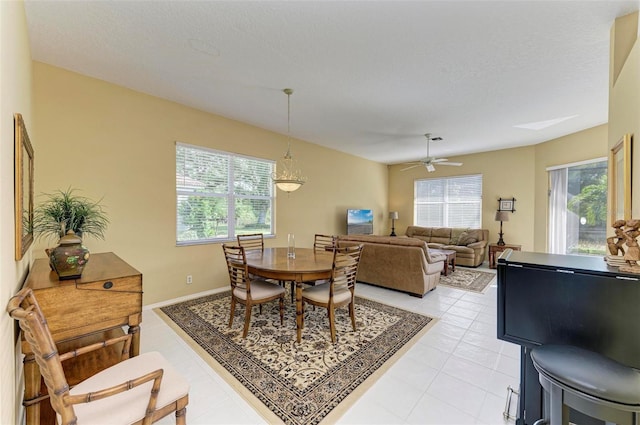 dining area featuring ceiling fan, light tile patterned flooring, and a textured ceiling