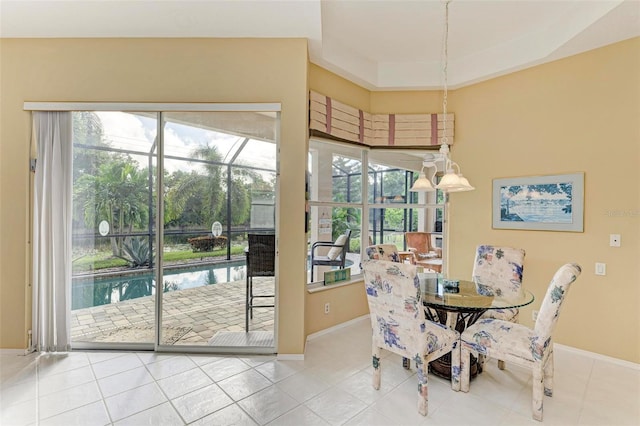 tiled dining area featuring a tray ceiling