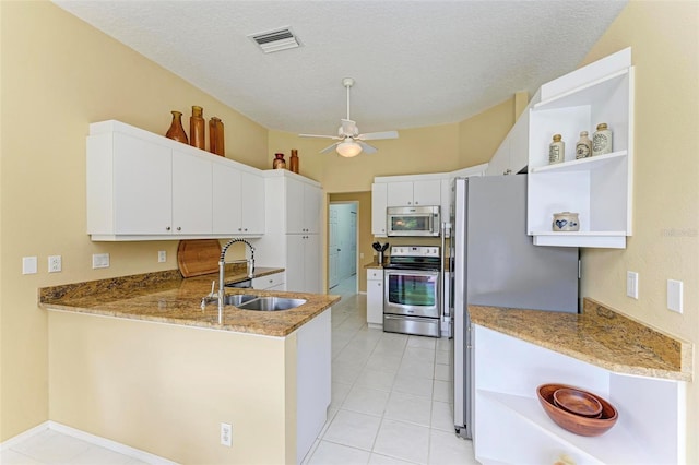 kitchen with kitchen peninsula, appliances with stainless steel finishes, a textured ceiling, sink, and white cabinets