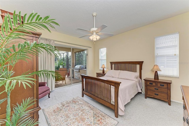 bedroom with multiple windows, light carpet, a textured ceiling, and ceiling fan