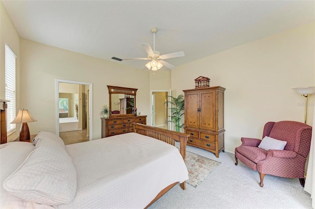 bedroom with ceiling fan, light carpet, and ensuite bath