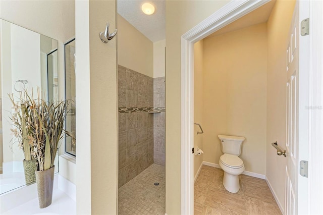 bathroom with tiled shower, a textured ceiling, and toilet