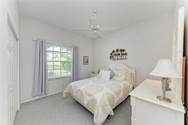 carpeted bedroom featuring ceiling fan, a textured ceiling, and a closet