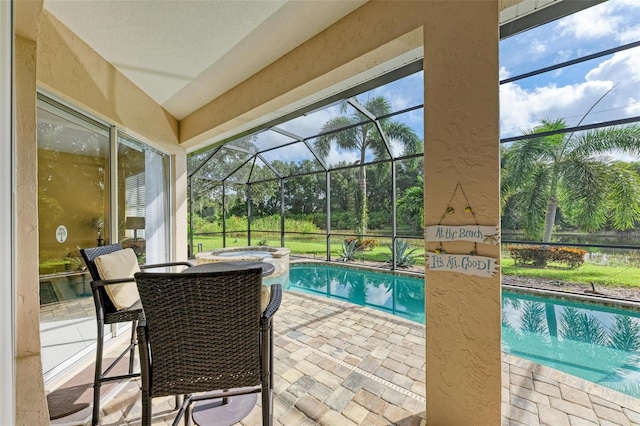 view of swimming pool with an in ground hot tub, a patio area, and a lanai