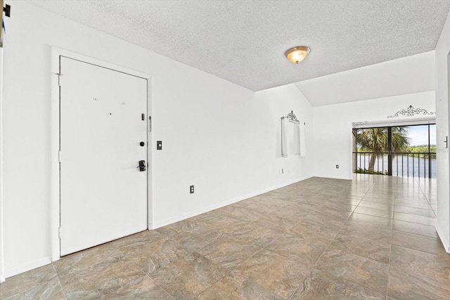 unfurnished room featuring a textured ceiling and baseboards