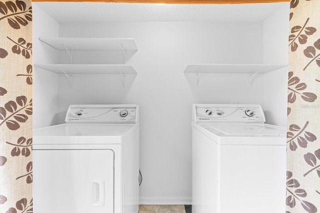 laundry room with attic access, independent washer and dryer, and a textured ceiling