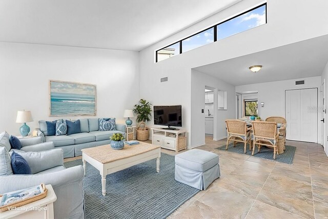 living area featuring visible vents and a towering ceiling