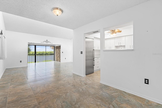 unfurnished room featuring a ceiling fan, baseboards, and a textured ceiling