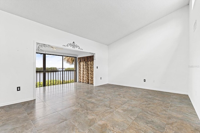 unfurnished living room with baseboards and a textured ceiling