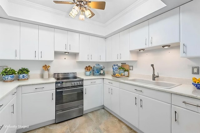 kitchen featuring a sink, crown molding, light countertops, and electric stove