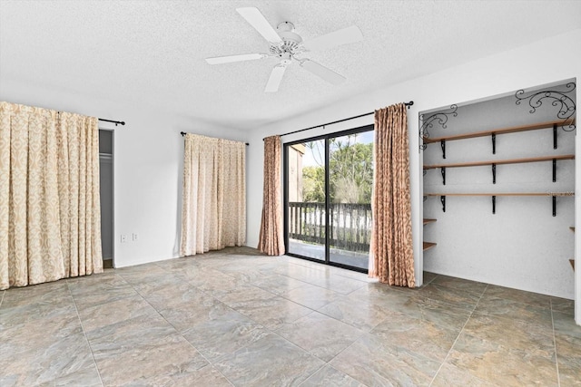 empty room featuring a textured ceiling and a ceiling fan