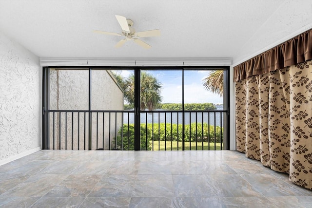 unfurnished sunroom featuring a water view and ceiling fan