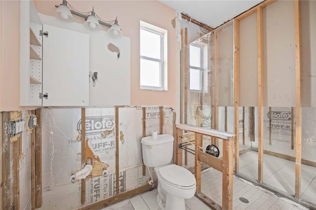 bathroom featuring toilet, walk in shower, and tile patterned floors