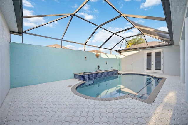 view of pool with glass enclosure and a patio