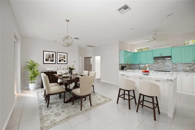 tiled dining room with ceiling fan with notable chandelier