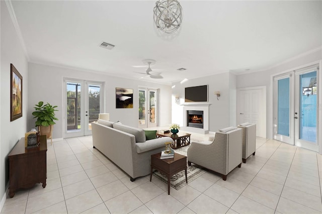 living room with ornamental molding, french doors, light tile patterned floors, and ceiling fan