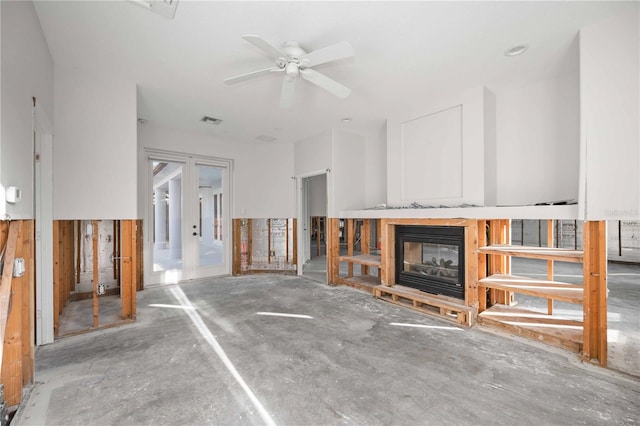 unfurnished living room featuring french doors and ceiling fan