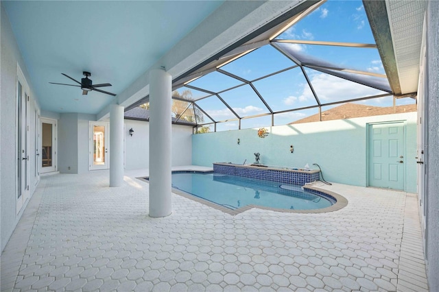 view of pool with glass enclosure, ceiling fan, and a patio