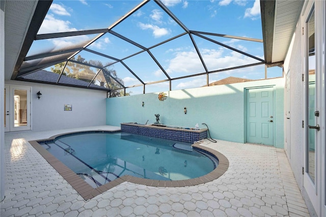 view of swimming pool featuring glass enclosure and a patio area