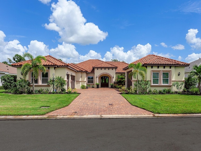 mediterranean / spanish house with a front lawn and a garage