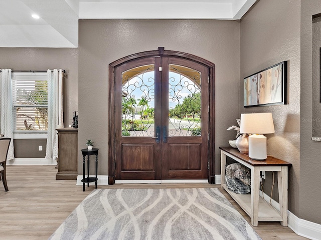 foyer entrance featuring a wealth of natural light, light wood-type flooring, and french doors