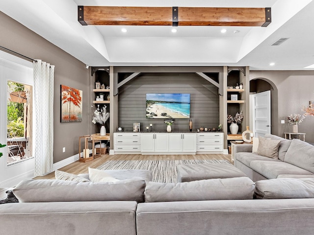 living room featuring light wood-type flooring and lofted ceiling with beams