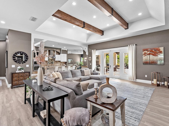 living room featuring light hardwood / wood-style flooring and beam ceiling