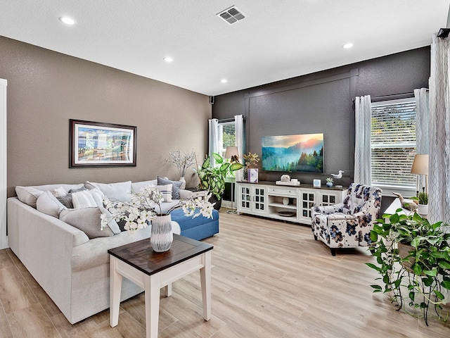 living room featuring a wealth of natural light and light hardwood / wood-style flooring