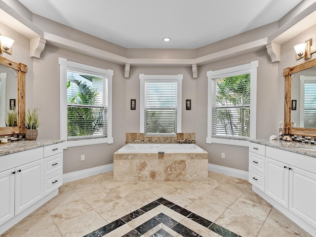 bathroom with a wealth of natural light, vanity, and a relaxing tiled tub