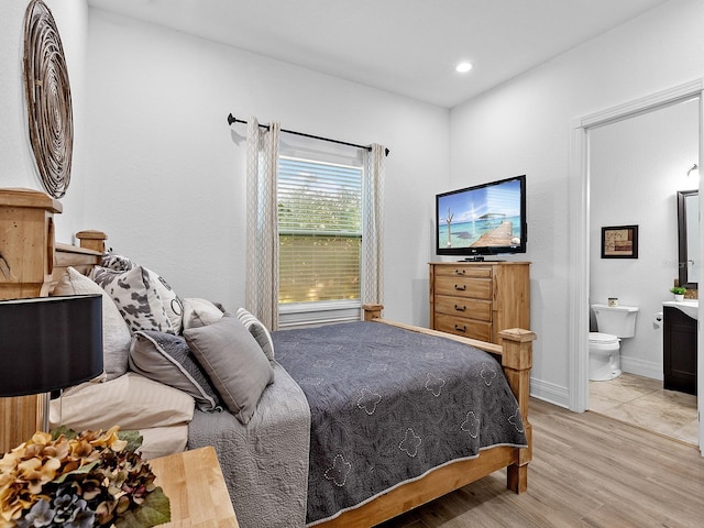 bedroom with light hardwood / wood-style flooring and connected bathroom