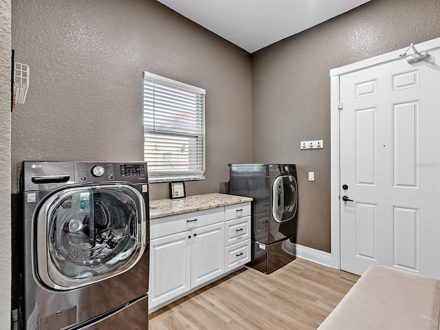 washroom with cabinets, washer and clothes dryer, and light wood-type flooring