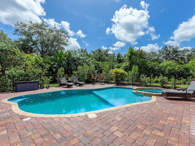 view of swimming pool featuring an in ground hot tub and a patio