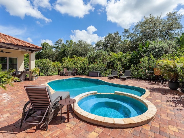 view of swimming pool featuring an in ground hot tub and a patio