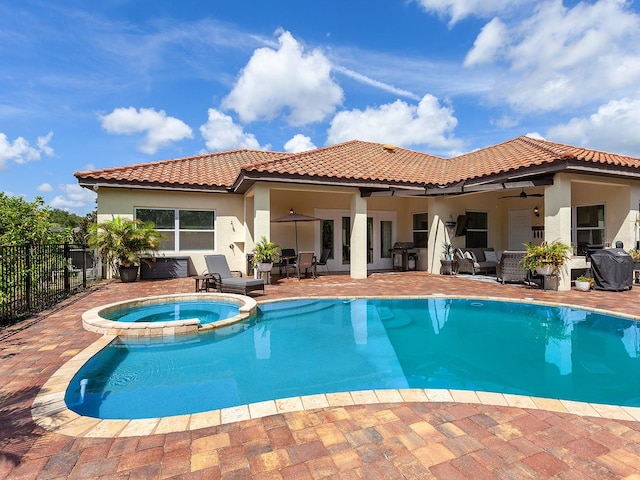 exterior space with ceiling fan, a patio, and a pool with hot tub