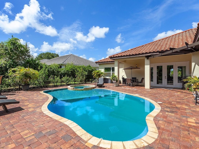 view of pool featuring a patio area, an in ground hot tub, and french doors