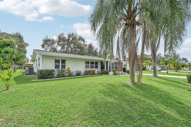 ranch-style house with cooling unit and a front lawn