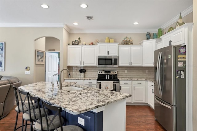 kitchen with a center island with sink, stainless steel appliances, sink, and white cabinetry