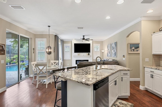 kitchen with dark hardwood / wood-style floors, a fireplace, dishwasher, sink, and ceiling fan