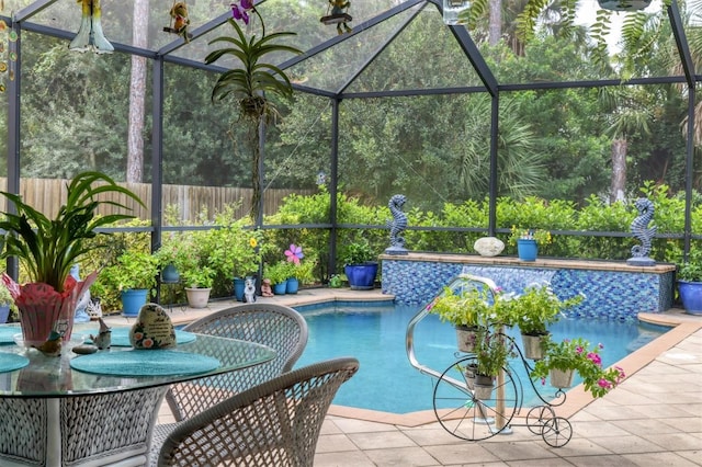 view of pool with glass enclosure and a patio area