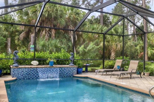 view of swimming pool featuring glass enclosure, pool water feature, and a patio