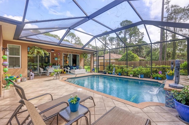 view of swimming pool with glass enclosure, pool water feature, and a patio area