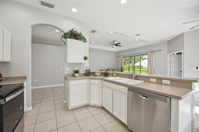 kitchen featuring sink, ceiling fan, a tray ceiling, appliances with stainless steel finishes, and light tile patterned flooring