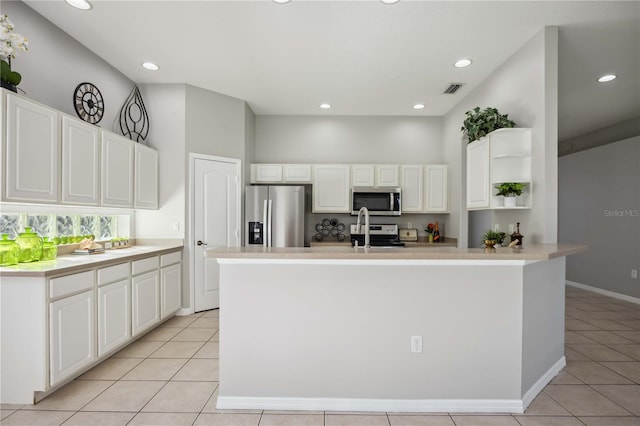 kitchen featuring stainless steel appliances, a center island with sink, light tile patterned floors, and white cabinets