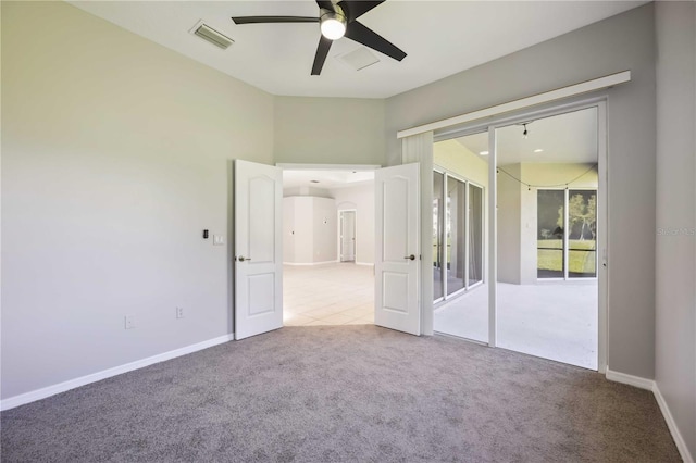 empty room featuring ceiling fan and carpet